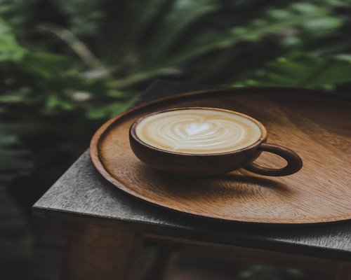 Secangkir kopi di meja kerja dekat jendela cerah di pagi hari
